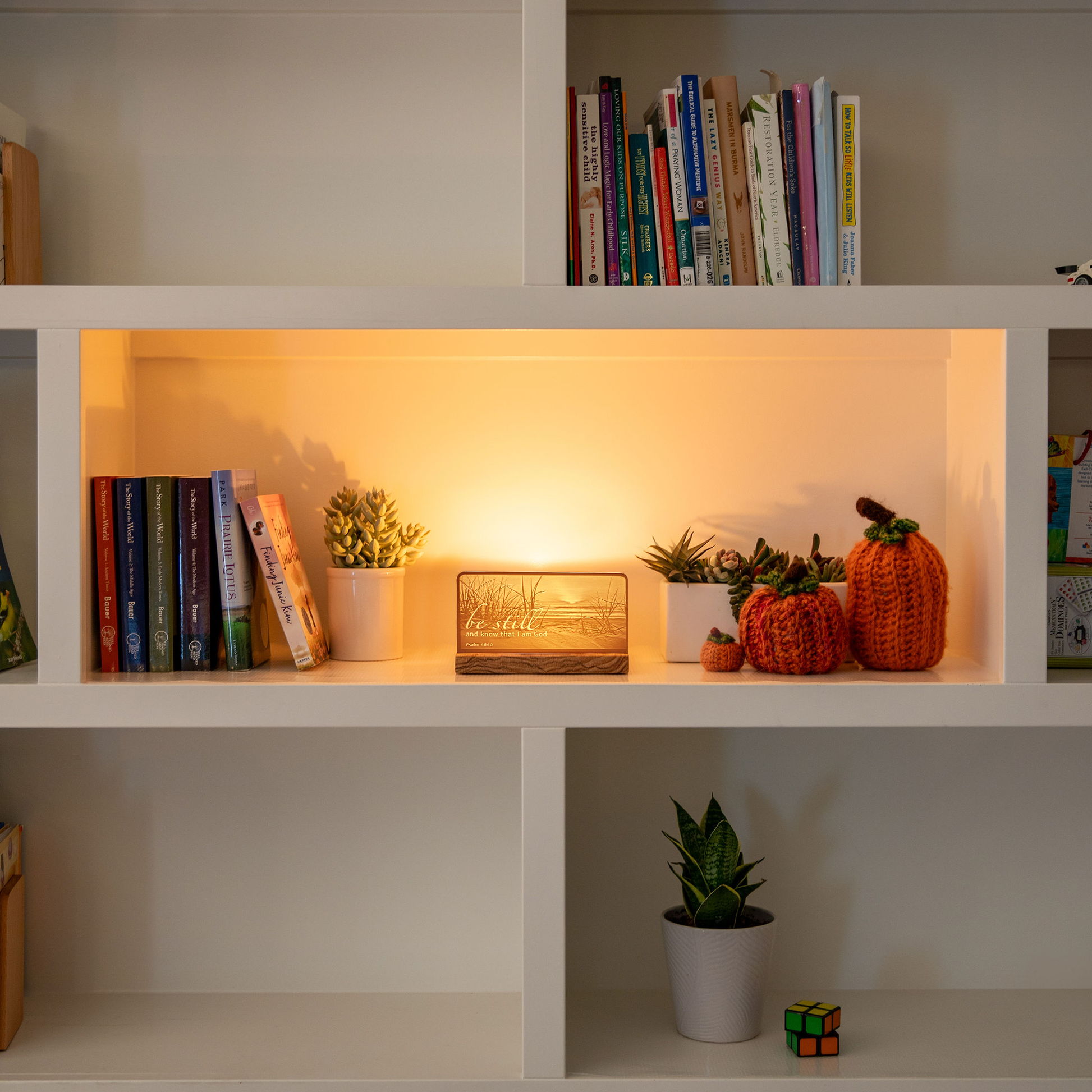 StoryLine-Mini lithophane photo display lit with Warm LED featuring a beach scene and encouraging Bible verse sitting on a contemporary home's bookshelf