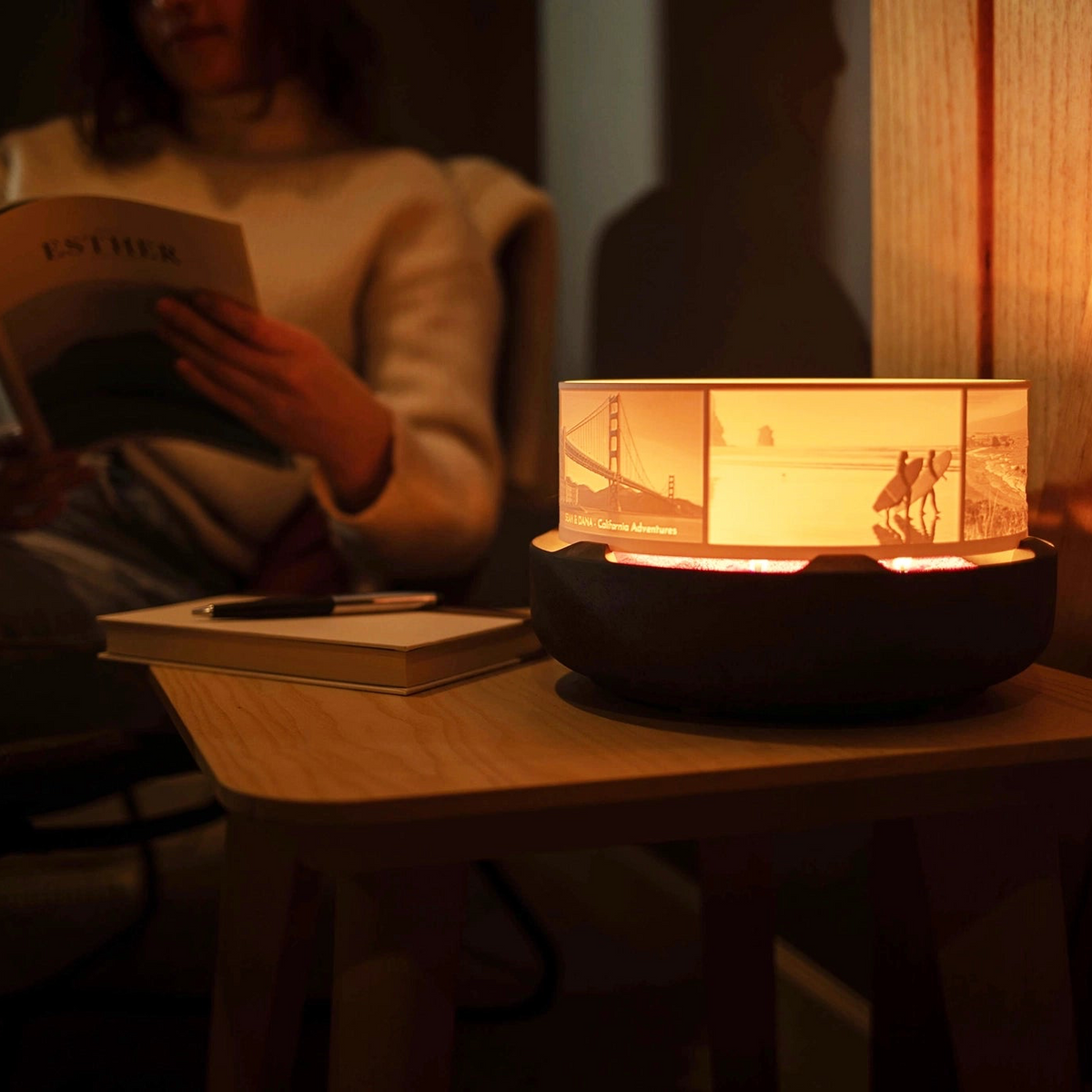 Halo Grande personalized lithophane photo display on a Concrete Base featuring California photos in a cosy home space with a woman reading in the background