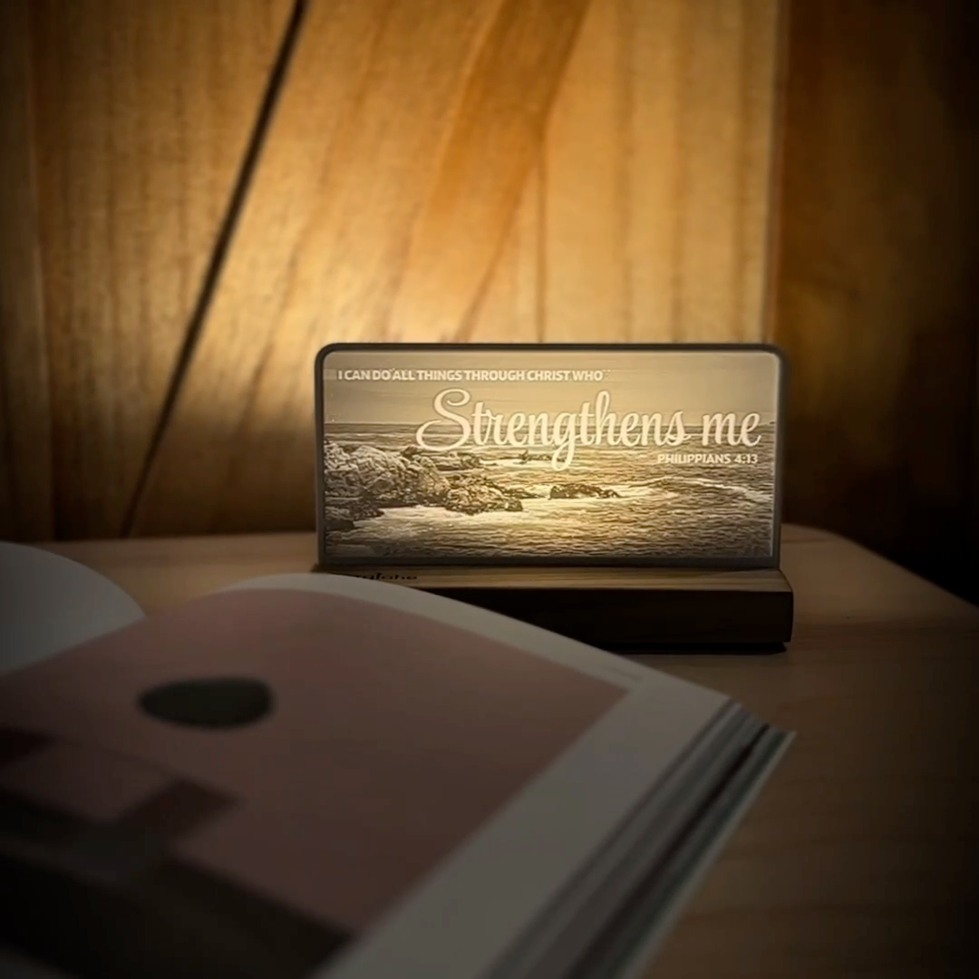 StoryLine-Mini lithophane photo display lit with Warm LED featuring a beach scene and encouraging Bible verse rotating on a small table