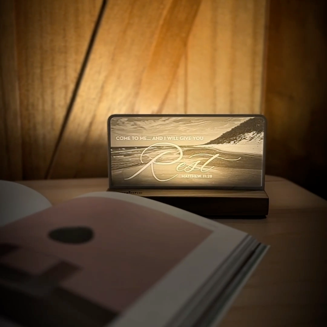 StoryLine-Mini lithophane photo display lit with Warm LED featuring a beach scene and encouraging Bible verse rotating on a small table