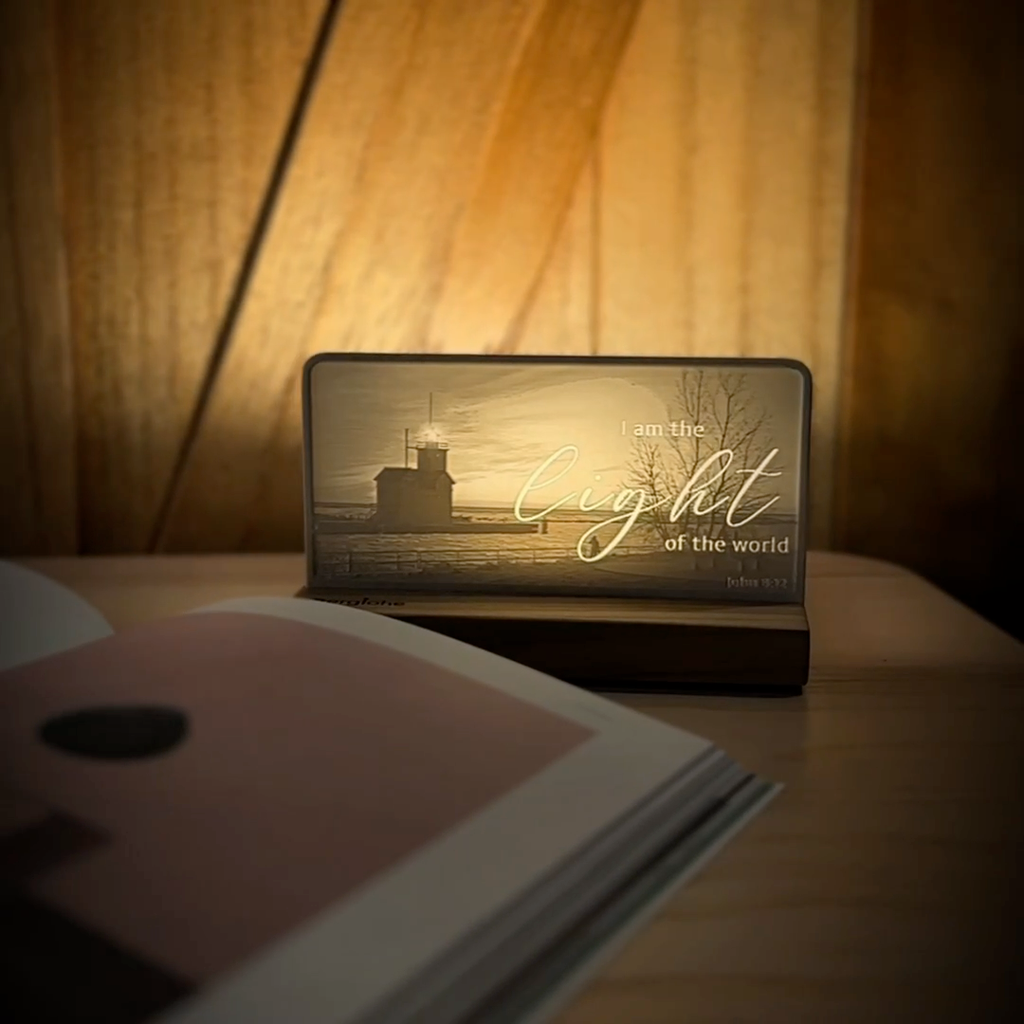 StoryLine-Mini lithophane photo display lit with Warm LED featuring a lighthouse beach scene and encouraging Bible verse rotating on a small table