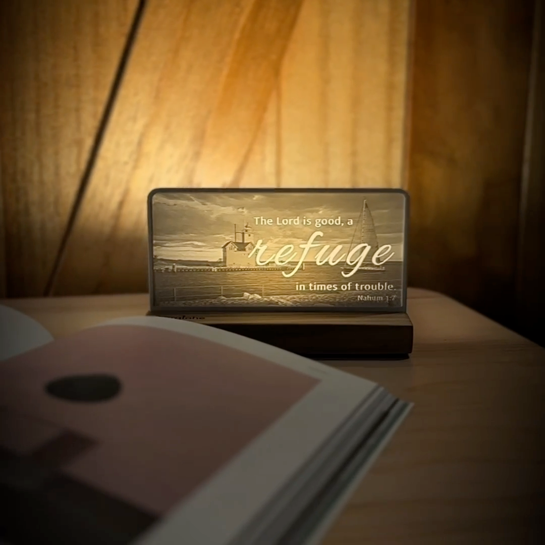 StoryLine-Mini lithophane photo display lit with Warm LED featuring a lighthouse beach scene and encouraging Bible verse rotating on a small table