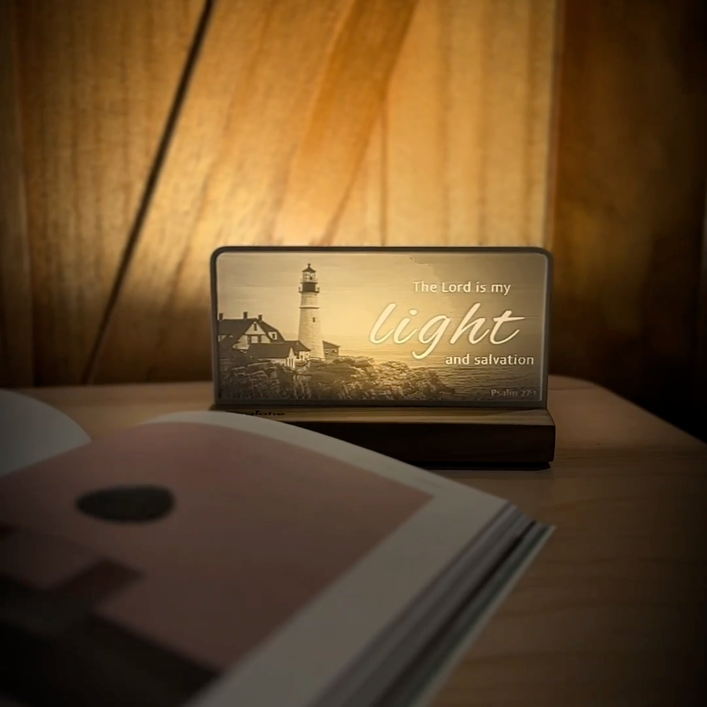 StoryLine-Mini lithophane photo display lit with Warm LED featuring a lighthouse beach scene and encouraging Bible verse rotating on a small table