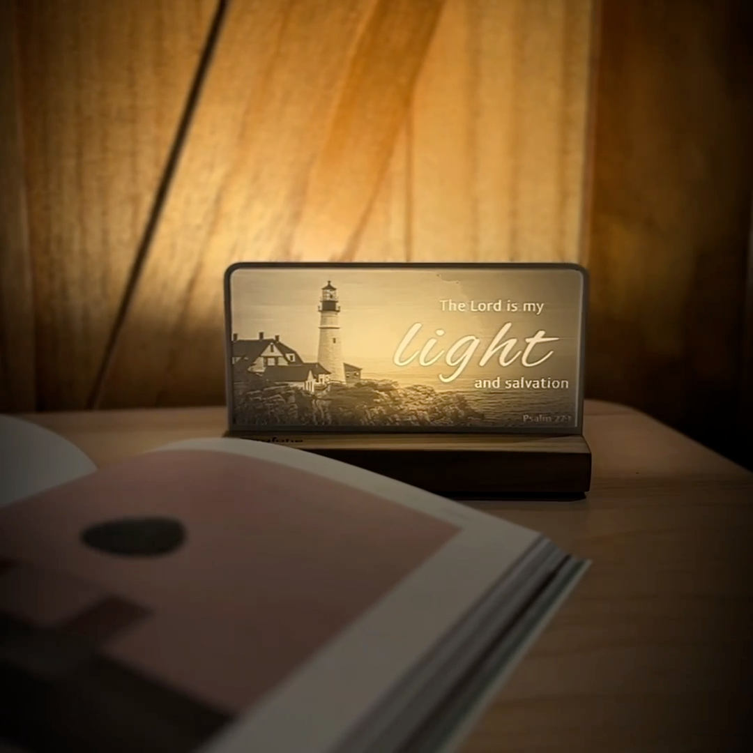 StoryLine-Mini lithophane photo display lit with Warm LED featuring a lighthouse beach scene and encouraging Bible verse rotating on a small table