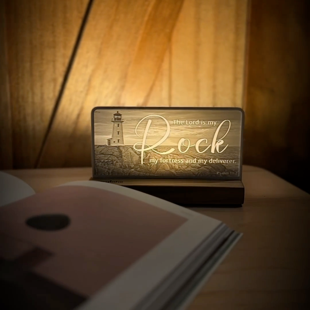 StoryLine-Mini lithophane photo display lit with Warm LED featuring a lighthouse beach scene and encouraging Bible verse rotating on a small table
