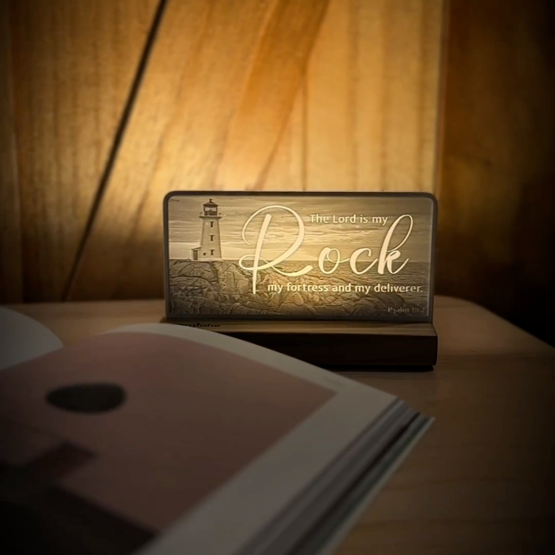 StoryLine-Mini lithophane photo display lit with Warm LED featuring a lighthouse beach scene and encouraging Bible verse rotating on a small table