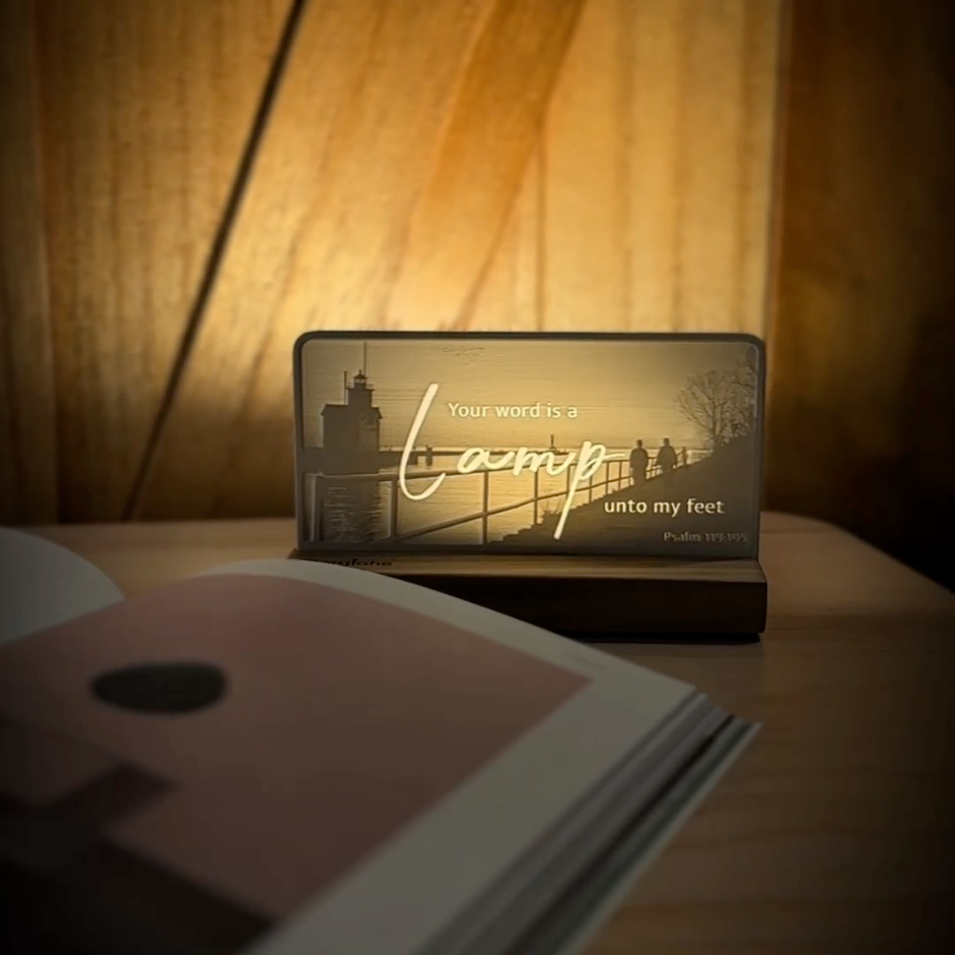 StoryLine-Mini lithophane photo display lit with Warm LED featuring a lighthouse beach scene and encouraging Bible verse rotating on a small table