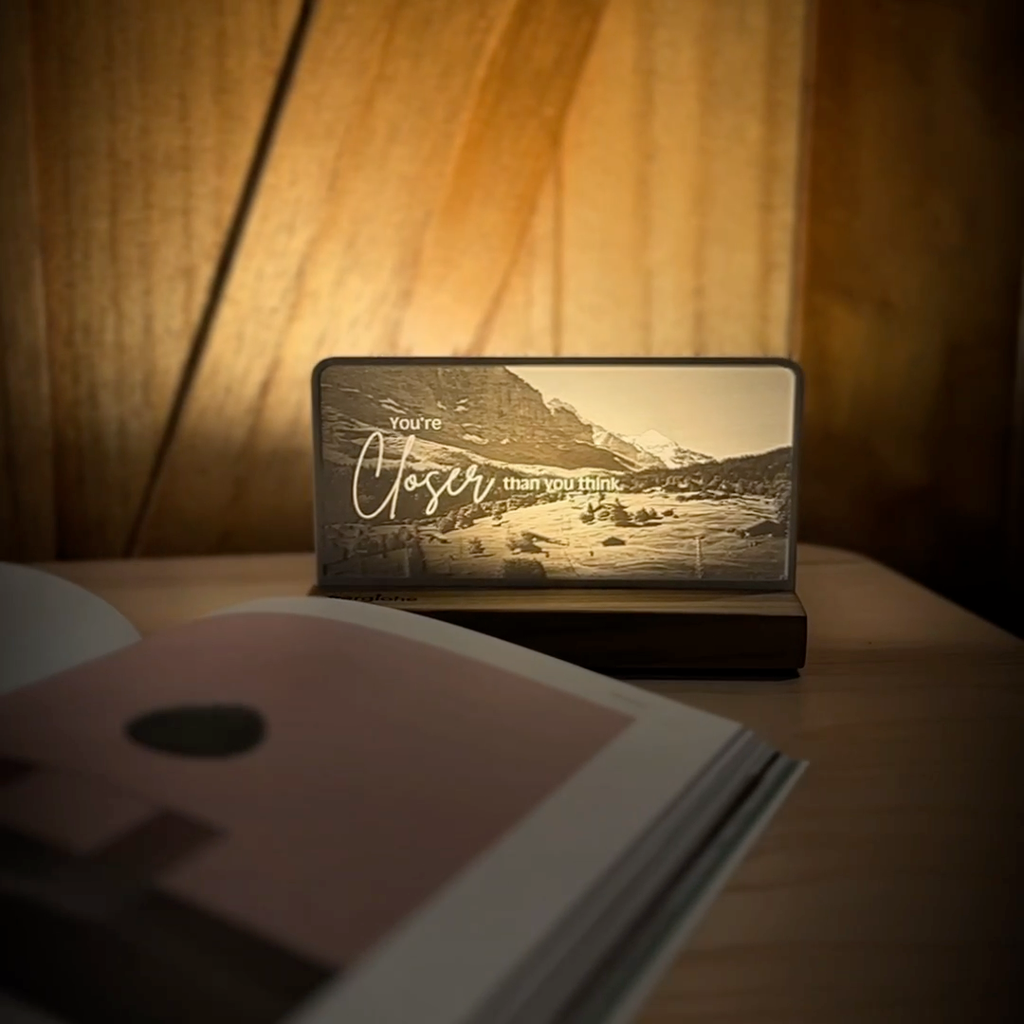StoryLine-Mini lithophane photo display lit with Warm LED featuring a mountain scene and encouraging saying rotating on a small table