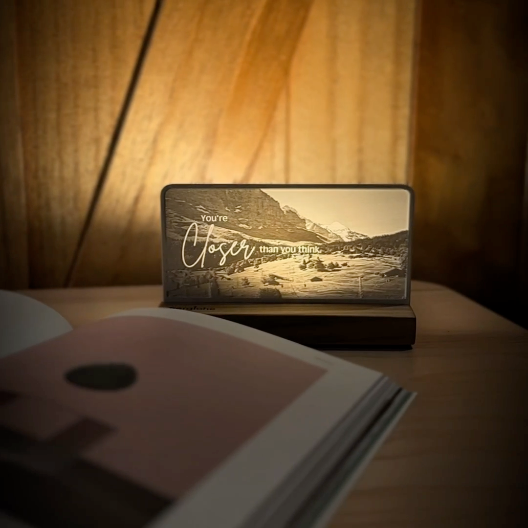 StoryLine-Mini lithophane photo display lit with Warm LED featuring a mountain scene and encouraging saying rotating on a small table
