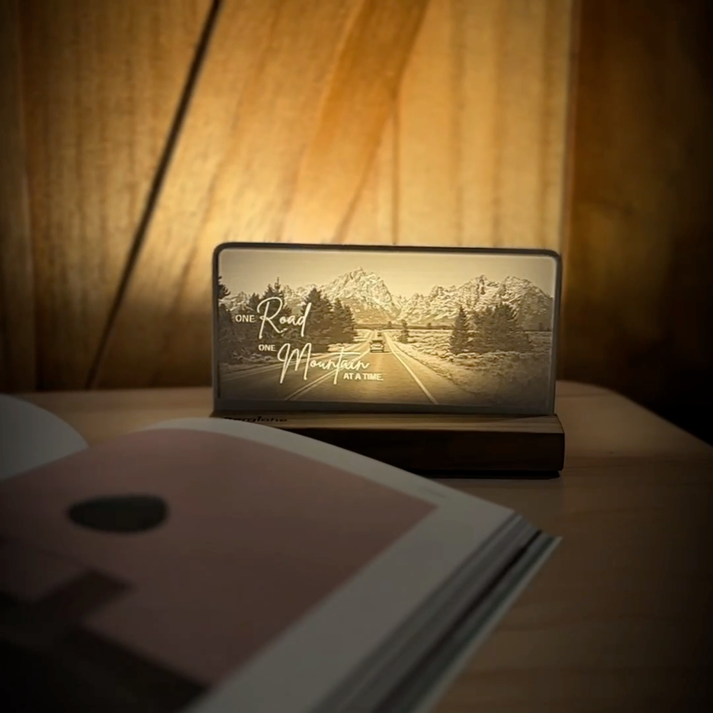 StoryLine-Mini lithophane photo display lit with Warm LED featuring a mountain scene and encouraging saying rotating on a small table