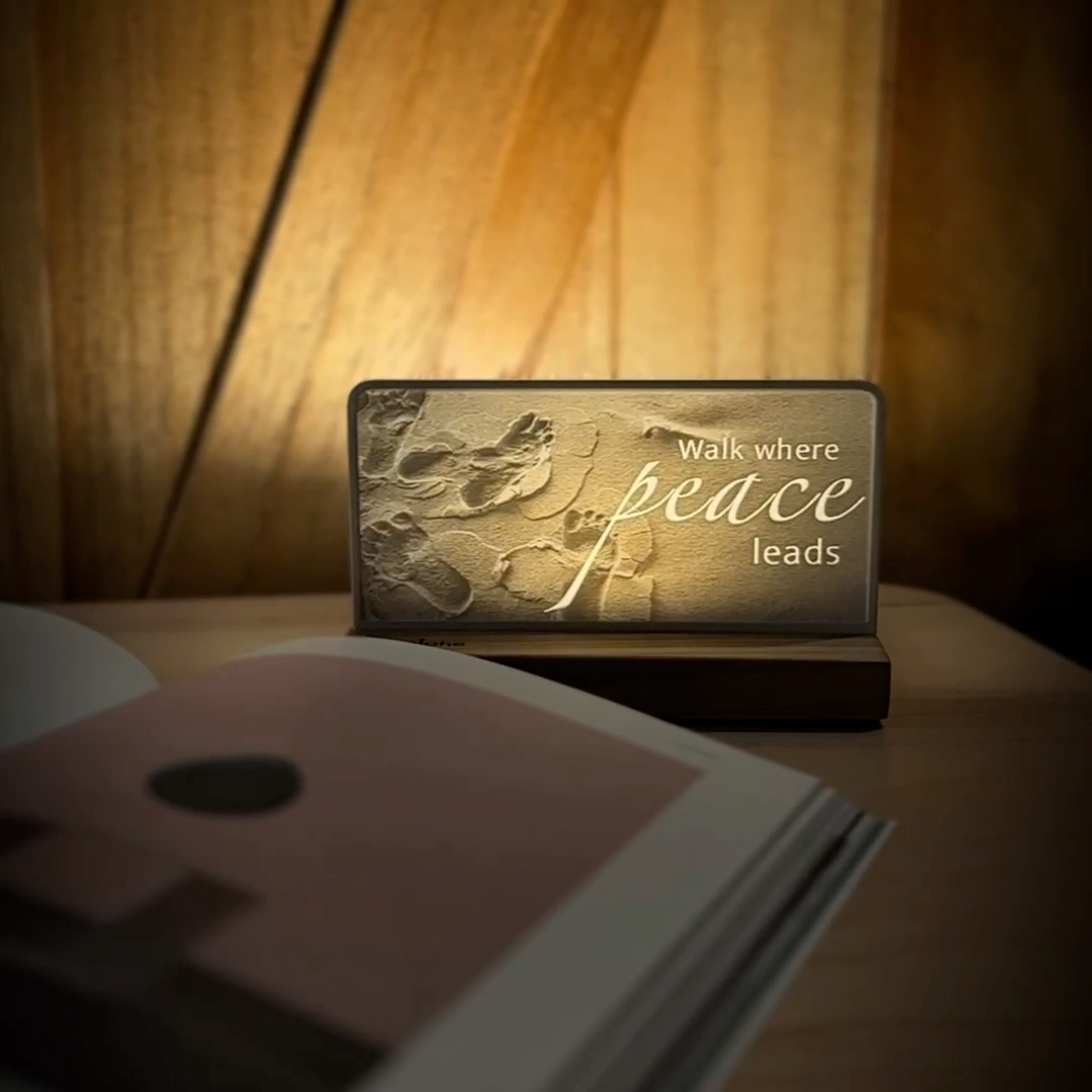 StoryLine-Mini lithophane photo display lit with Warm LED featuring a beach scene and encouraging saying rotating on a small table