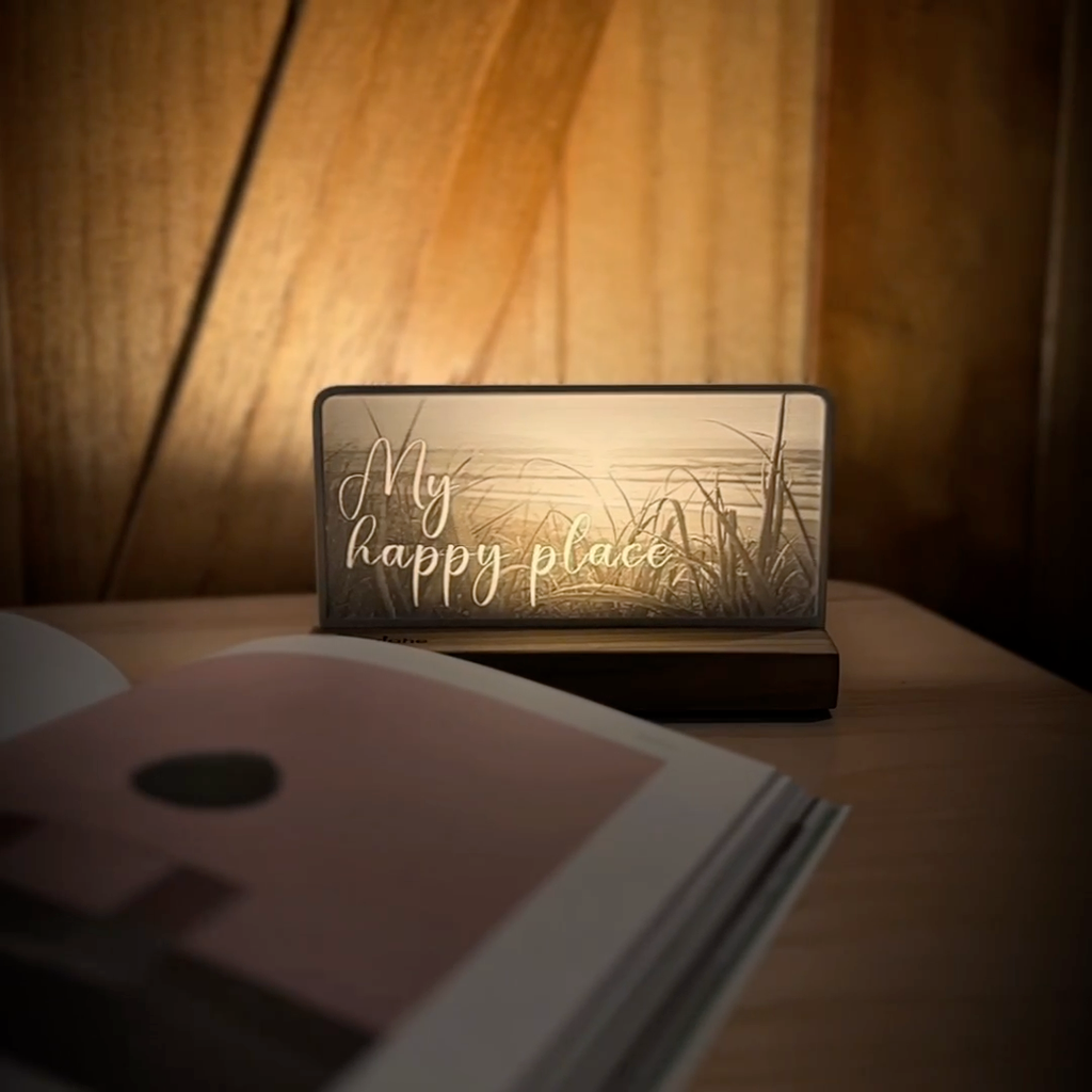 StoryLine-Mini lithophane photo display lit with Warm LED featuring a beach scene and encouraging saying rotating on a small table