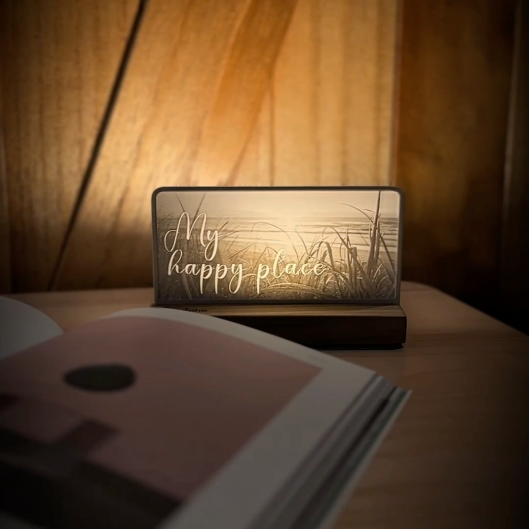 StoryLine-Mini lithophane photo display lit with Warm LED featuring a beach scene and encouraging saying rotating on a small table