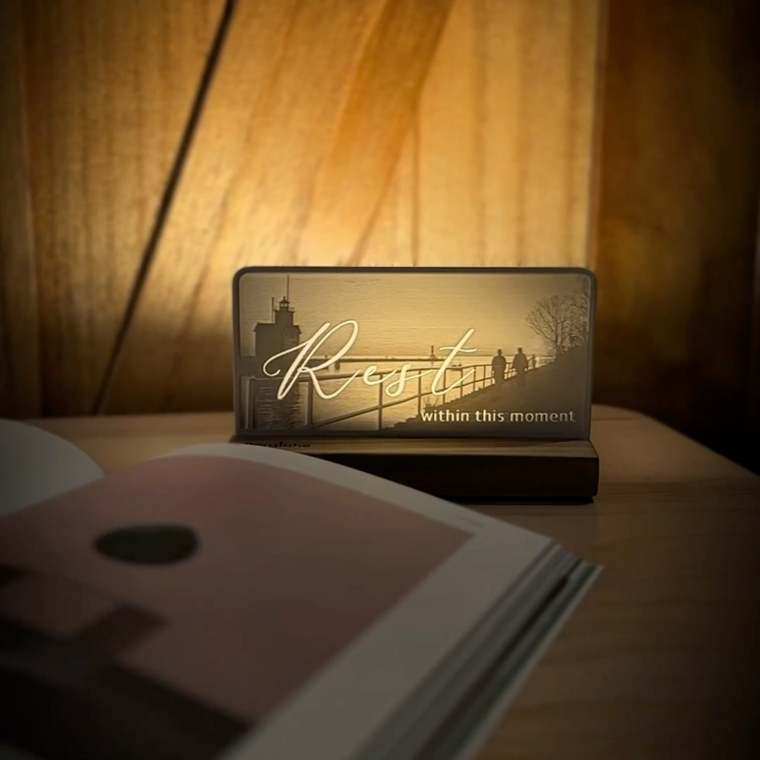 StoryLine-Mini lithophane photo display lit with Warm LED featuring a beach lighthouse scene and encouraging saying rotating on a small table